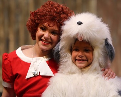 Annie and her dog Sandy, from the musical "Annie Jr" smile happily.